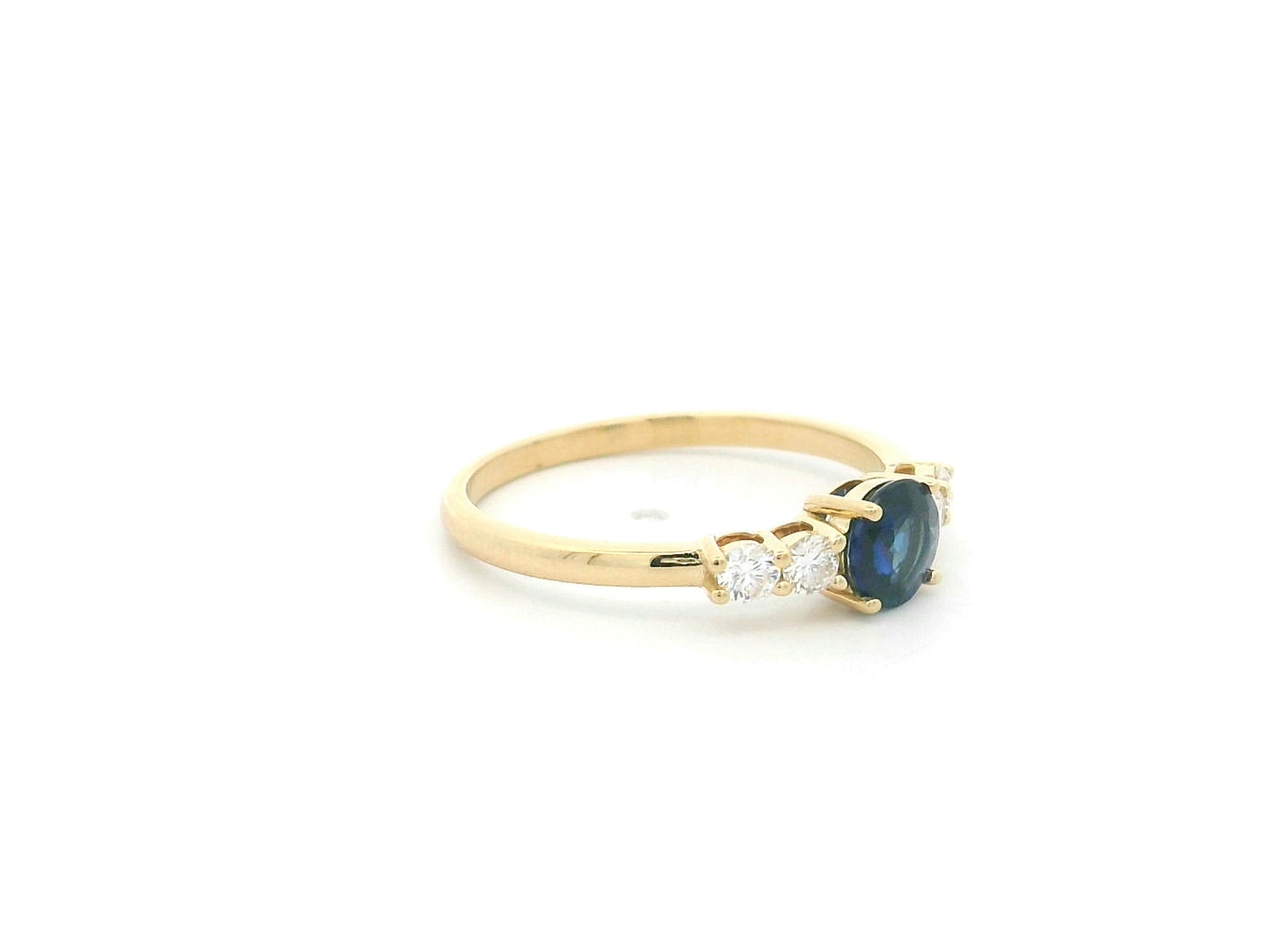 Natural Blue Sapphire and Diamond Ring in 18K Yellow Gold featuring a 0.65 carat round blue sapphire with 0.25 carat natural diamond side stones.
