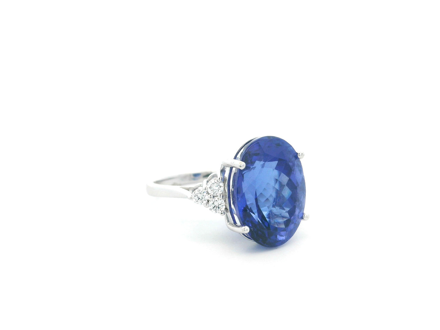 Natural 14.12 carat oval tanzanite and diamond ring in 18K white gold with natural diamond shoulders.