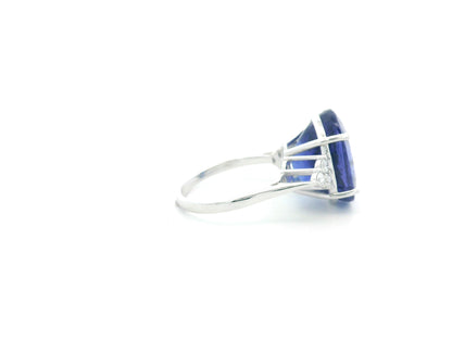 Natural 14.12 carat oval tanzanite and diamond ring in 18K white gold with natural diamond shoulders.