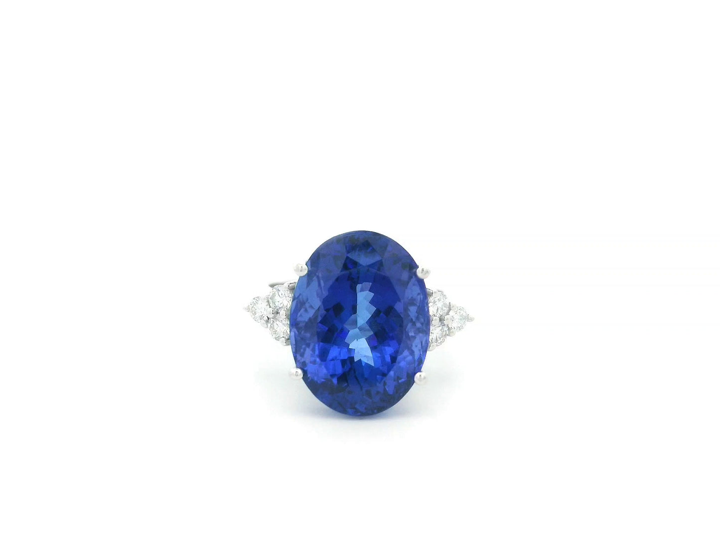 Natural 14.12 carat oval tanzanite and diamond ring in 18K white gold with natural diamond shoulders.