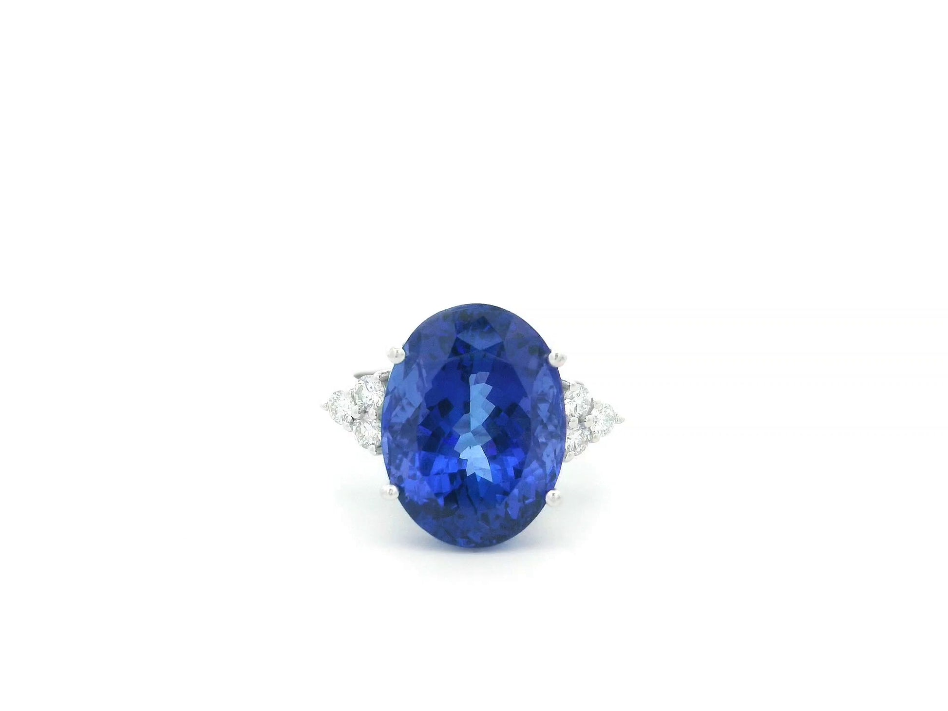 Natural 14.12 carat oval tanzanite and diamond ring in 18K white gold with natural diamond shoulders.