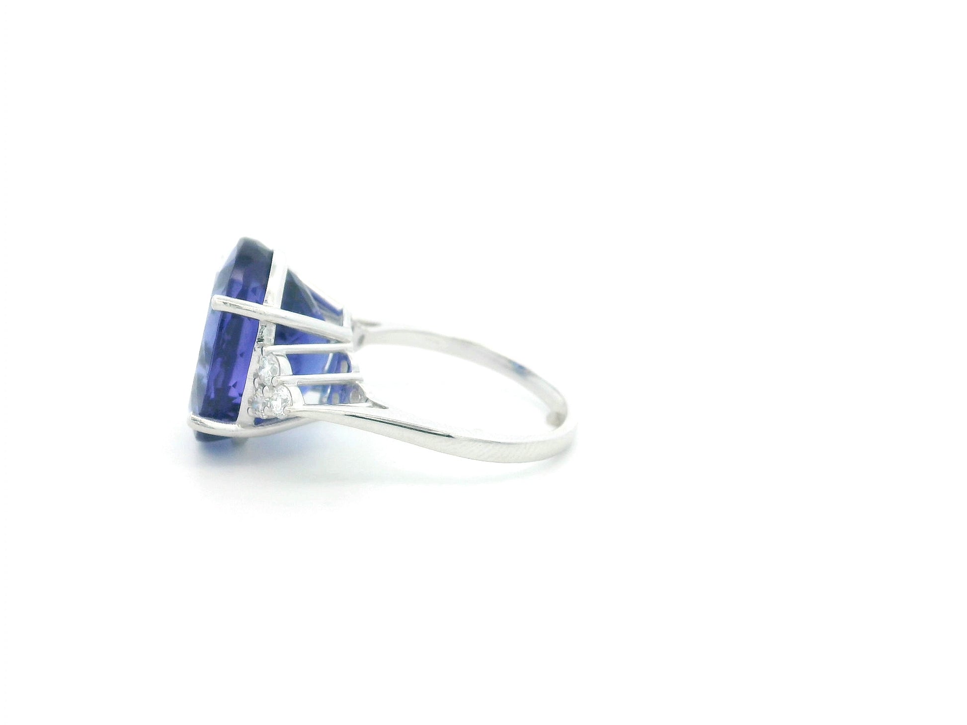 Natural 14.12 carat oval tanzanite and diamond ring in 18K white gold with natural diamond shoulders.