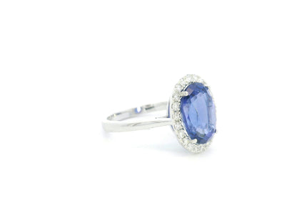 18K white gold halo ring featuring a 4.95 carat oval tanzanite surrounded by 0.37 carat natural diamonds.
