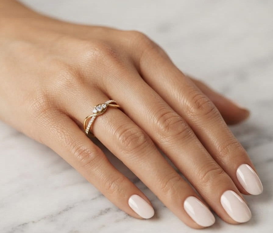 Natural diamond infinity ring in solid 18K yellow gold featuring 0.28 carat round brilliant diamonds in an elegant flowing infinity design.