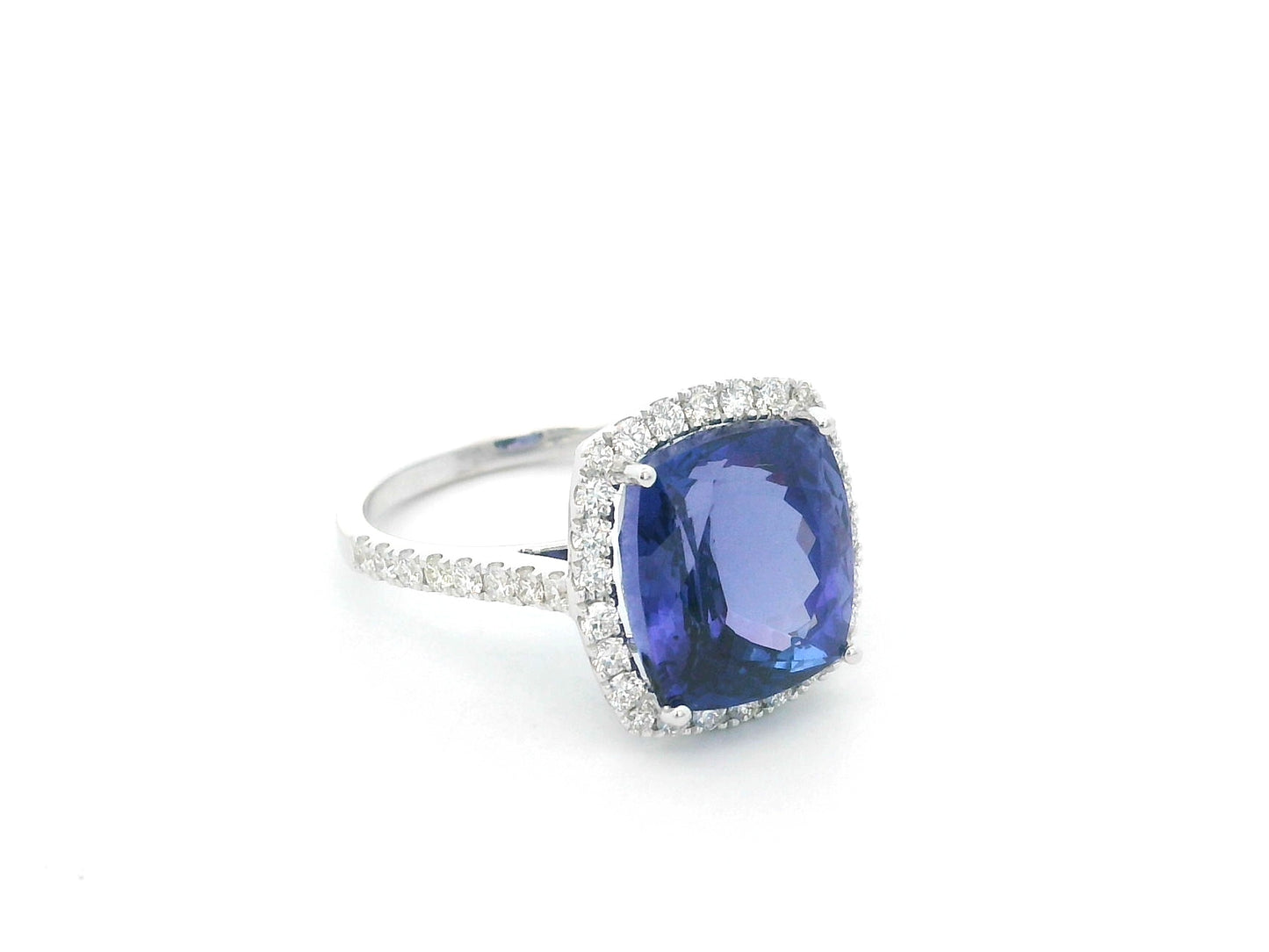 18K white gold cushion cut tanzanite halo ring featuring an 8.95 carat natural tanzanite surrounded by 0.69 carat natural diamonds with diamond-set shoulders.