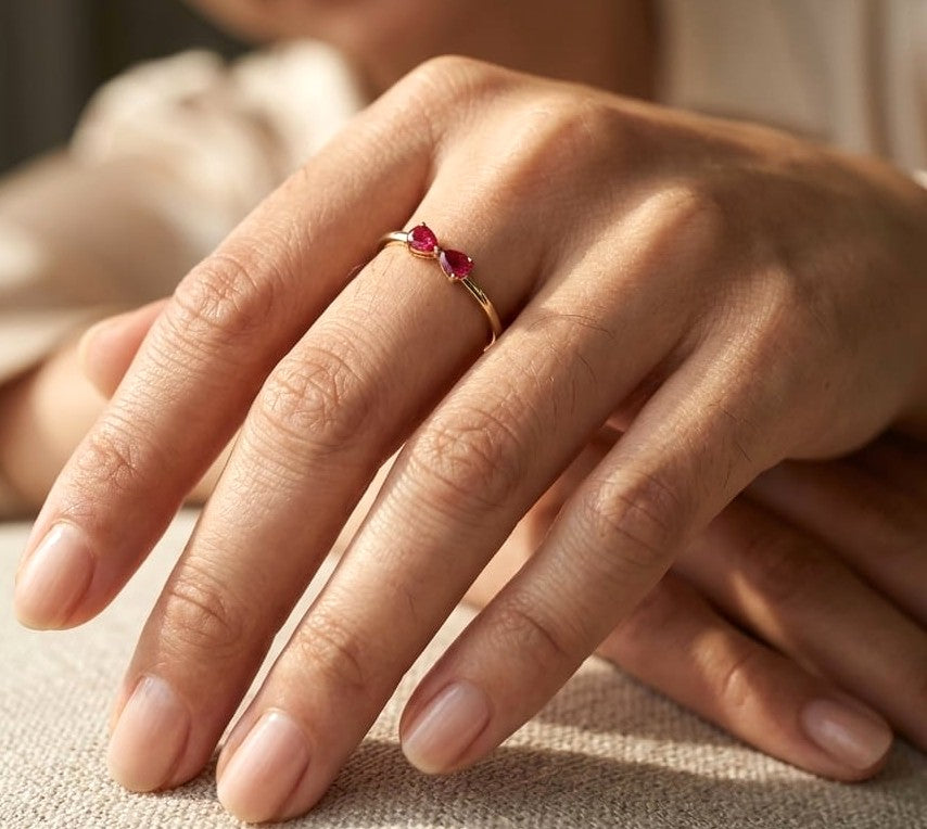 18K yellow gold ruby ring featuring two natural pear-shaped rubies in a delicate ring design.