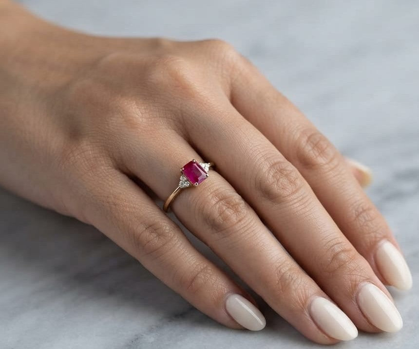 18K yellow gold emerald cut ruby ring featuring a 0.97 Carat natural ruby with sparkling natural diamond side accents.