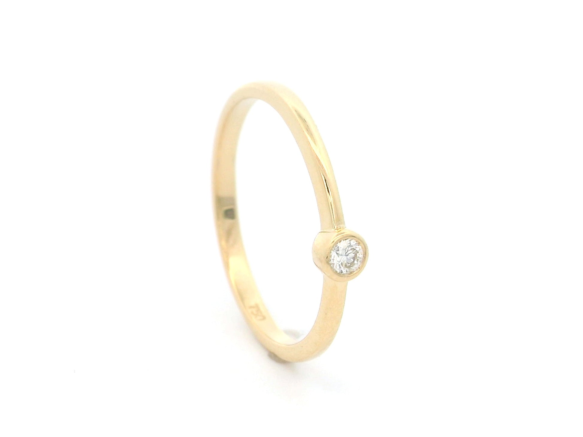 18K yellow gold bezel set diamond ring featuring a 0.07 carat natural round brilliant diamond in a minimalist solitaire design.