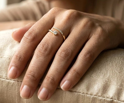 18K yellow gold open diamond ring featuring a round brilliant diamond with a curved row of natural diamonds in a minimalist wrap design.