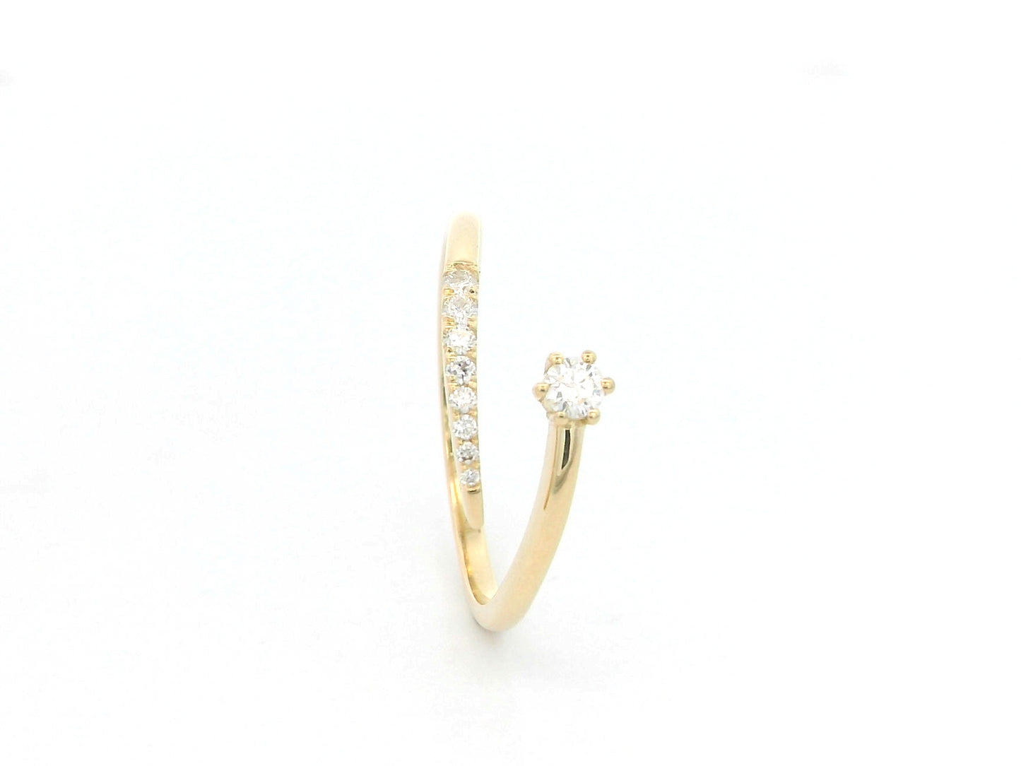 18K yellow gold open diamond ring featuring a round brilliant diamond with a curved row of natural diamonds in a minimalist wrap design.
