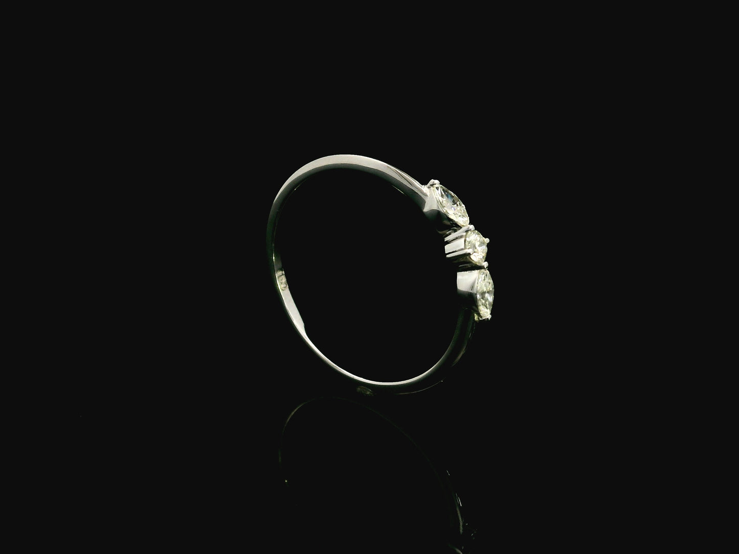 18K white gold three stone diamond ring featuring two marquise-cut diamonds and one round brilliant diamond with a total diamond weight of 0.22 carats.