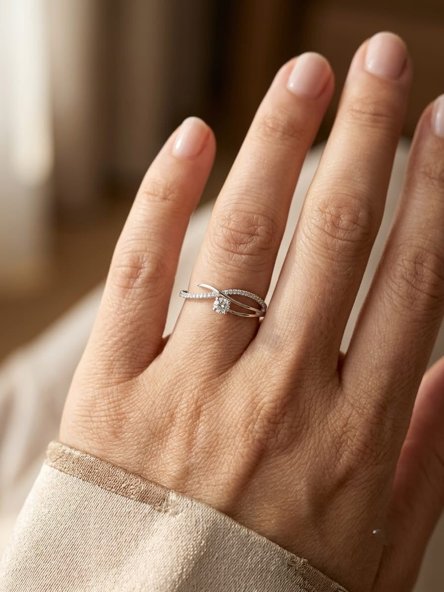 Elegant 18K white gold twist diamond ring featuring a brilliant round centre diamond with flowing pavé diamond crossover band by Emirates Diamonds.