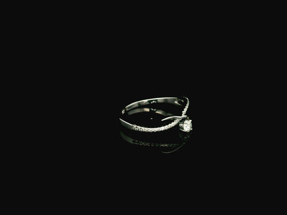 Elegant 18K white gold twist diamond ring featuring a brilliant round centre diamond with flowing pavé diamond crossover band by Emirates Diamonds.