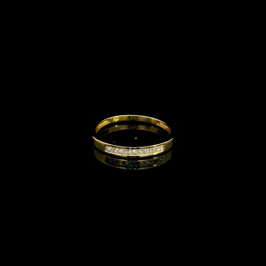 18K yellow gold princess cut diamond ring featuring 0.20 carat natural channel set diamonds in a polished minimalist band.