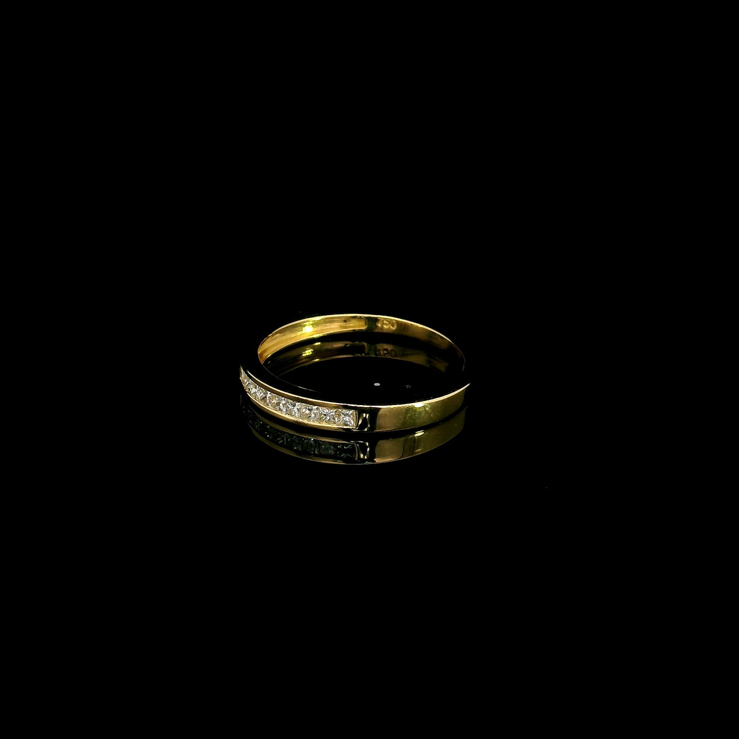 18K yellow gold princess cut diamond ring featuring 0.20 carat natural channel set diamonds in a polished minimalist band.