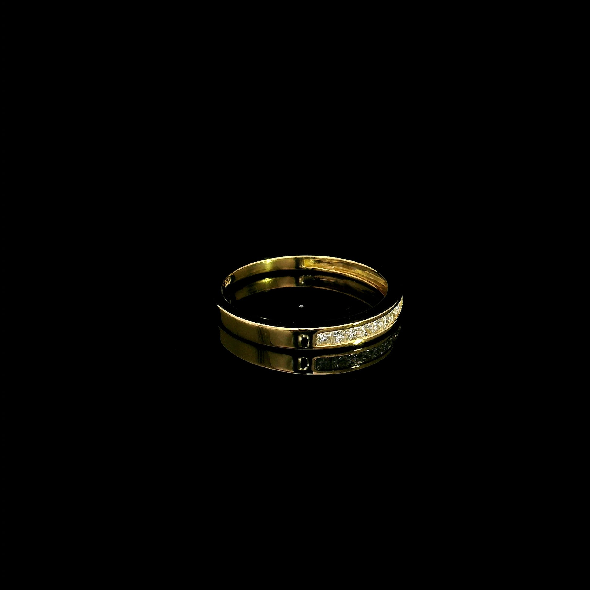 18K yellow gold princess cut diamond ring featuring 0.20 carat natural channel set diamonds in a polished minimalist band.