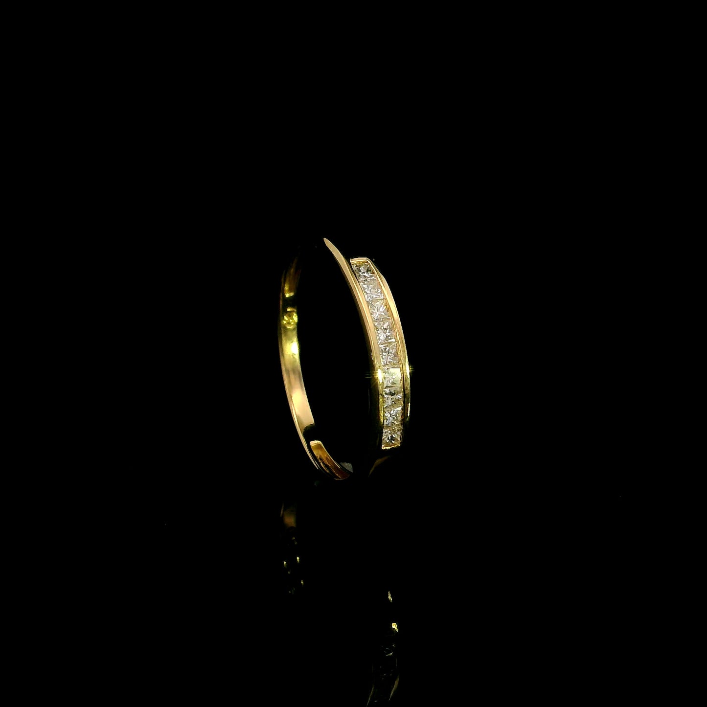 18K yellow gold princess cut diamond ring featuring 0.20 carat natural channel set diamonds in a polished minimalist band.