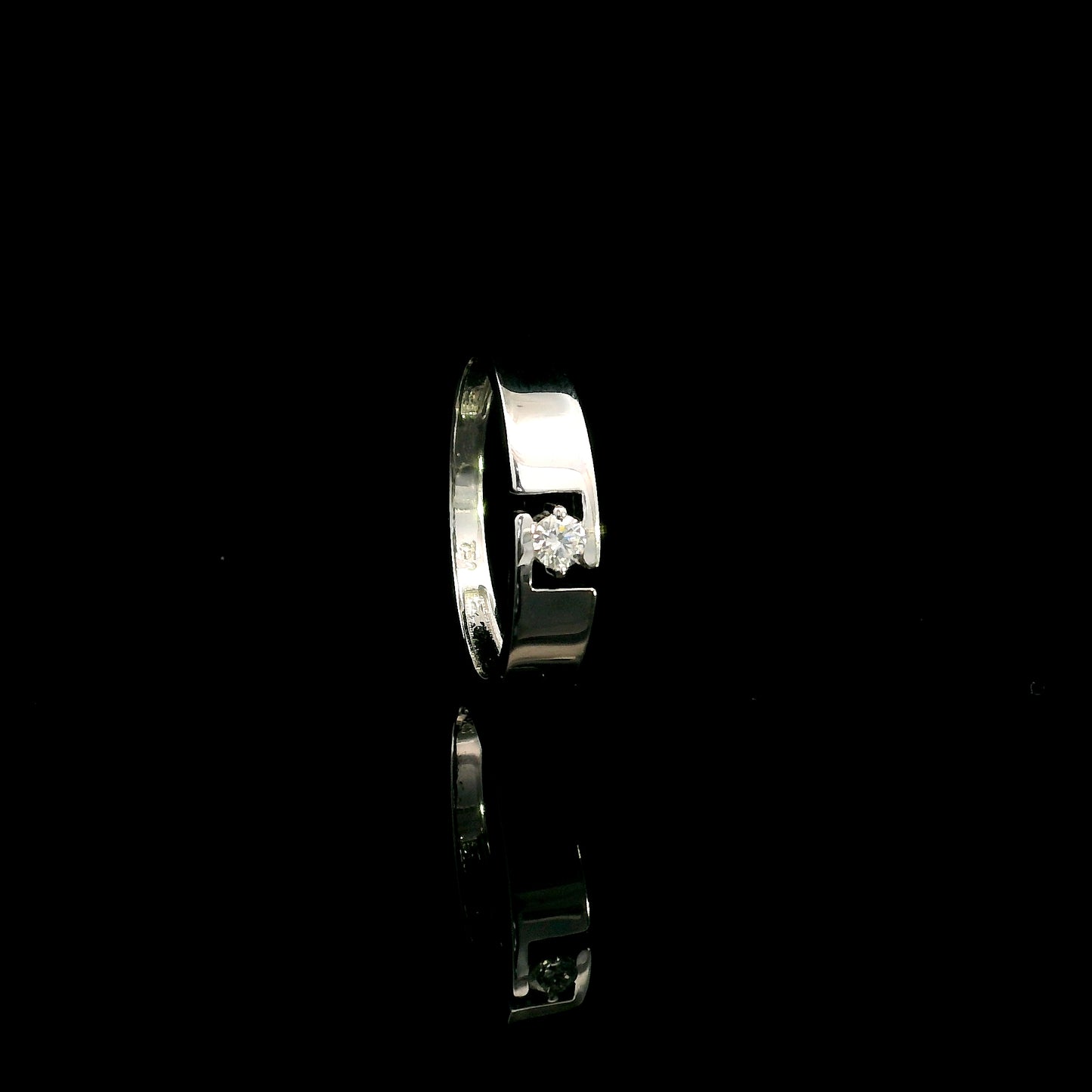18K white gold floating diamond ring featuring a 0.08 carat natural round brilliant solitaire in a modern open band.