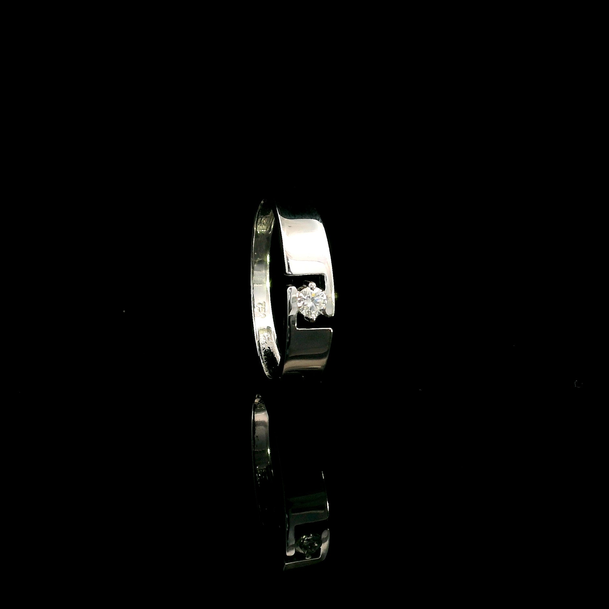 18K white gold floating diamond ring featuring a 0.08 carat natural round brilliant solitaire in a modern open band.