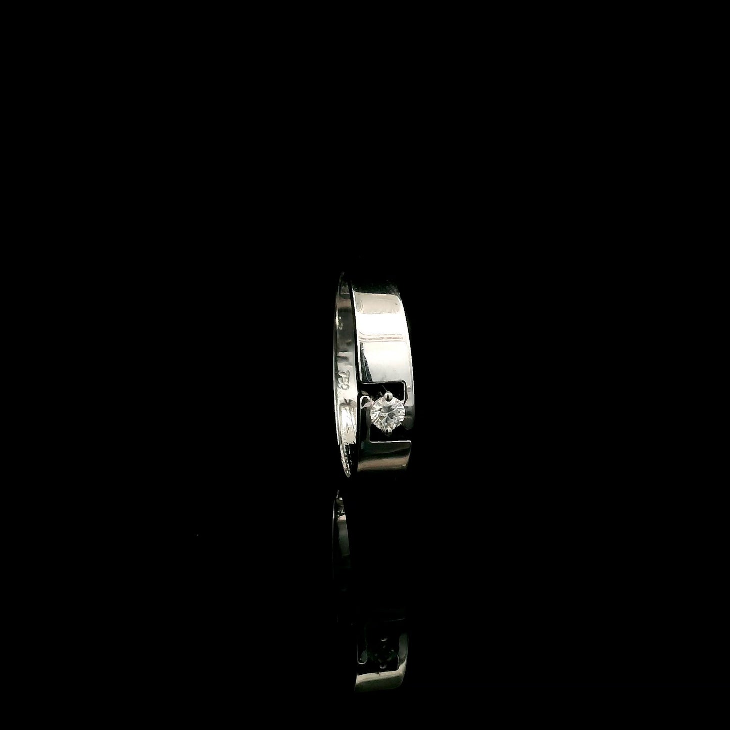 18K white gold floating diamond ring featuring a 0.08 carat natural round brilliant solitaire in a modern open band.