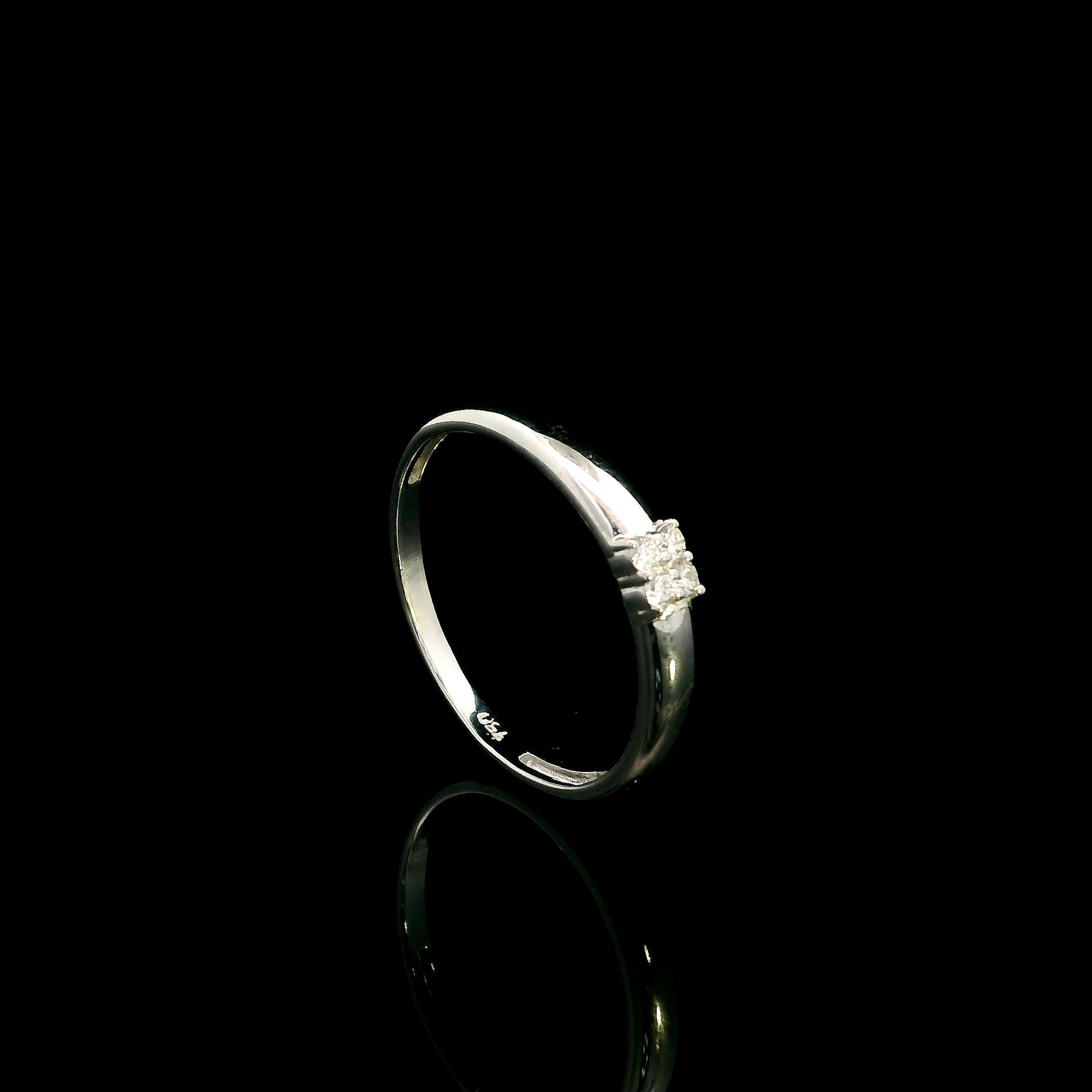 Minimalist natural diamond ring crafted in 18K white gold featuring a polished band with a four-diamond cluster.