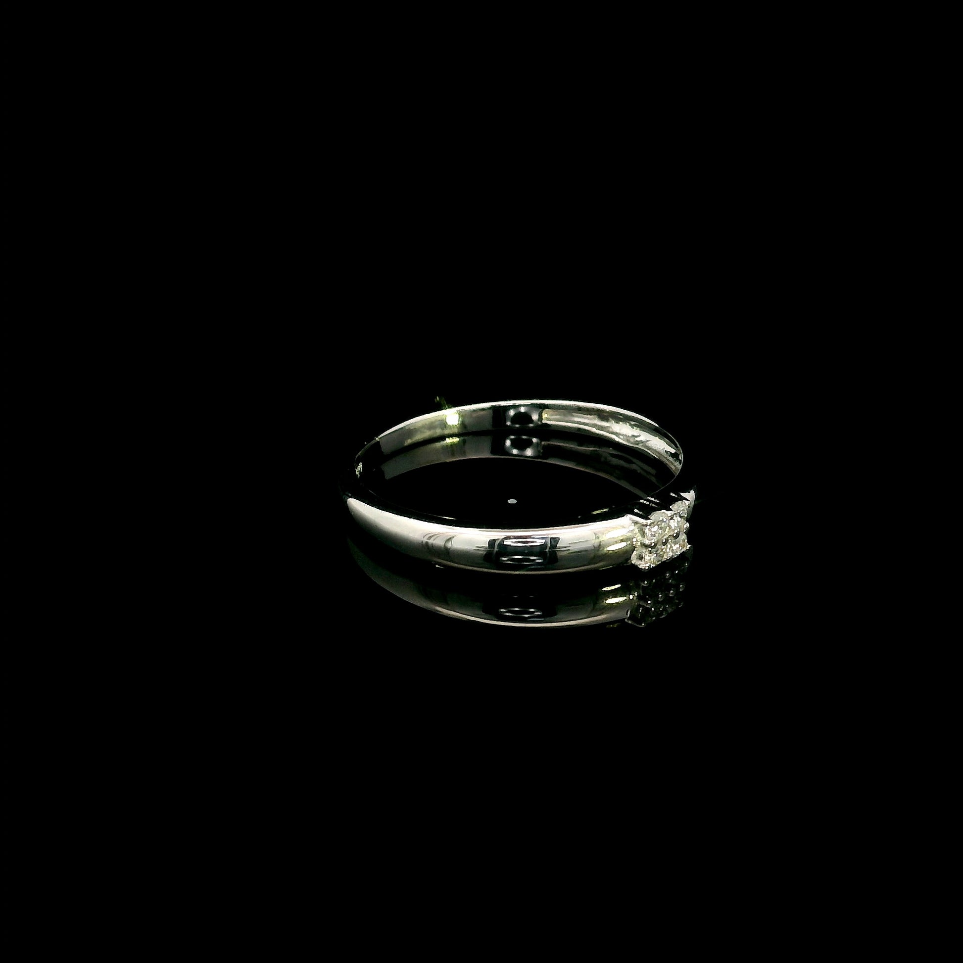 Minimalist natural diamond ring crafted in 18K white gold featuring a polished band with a four-diamond cluster.