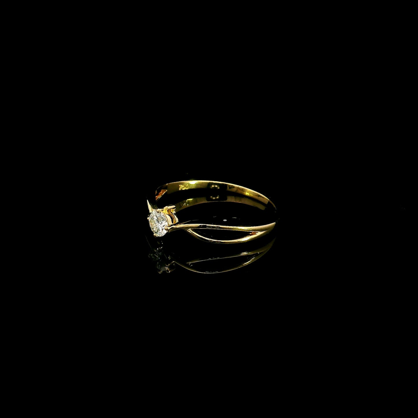 18K yellow gold twist solitaire ring featuring a 0.16 carat natural round brilliant diamond in a four-prong setting.