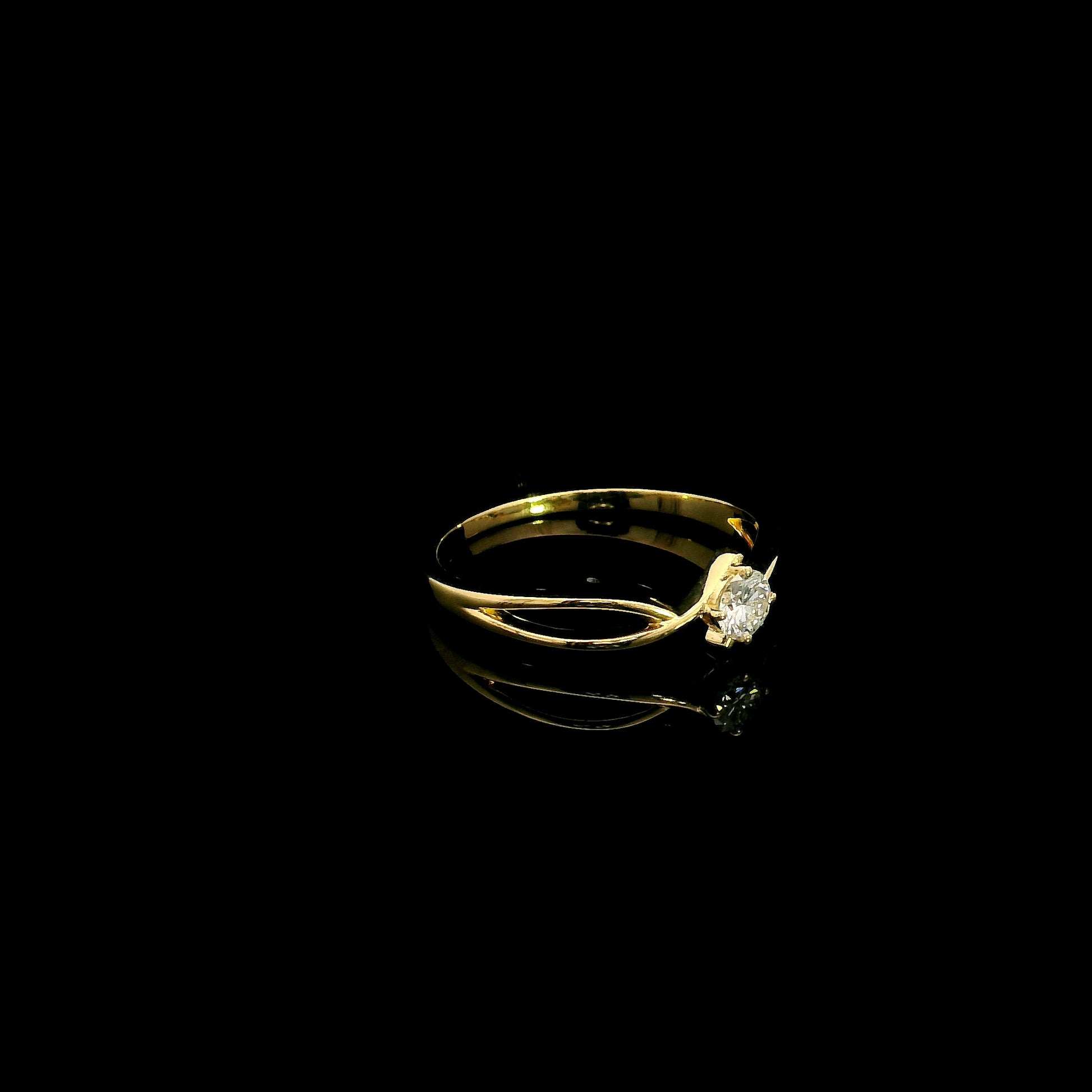 18K yellow gold twist solitaire ring featuring a 0.16 carat natural round brilliant diamond in a four-prong setting.