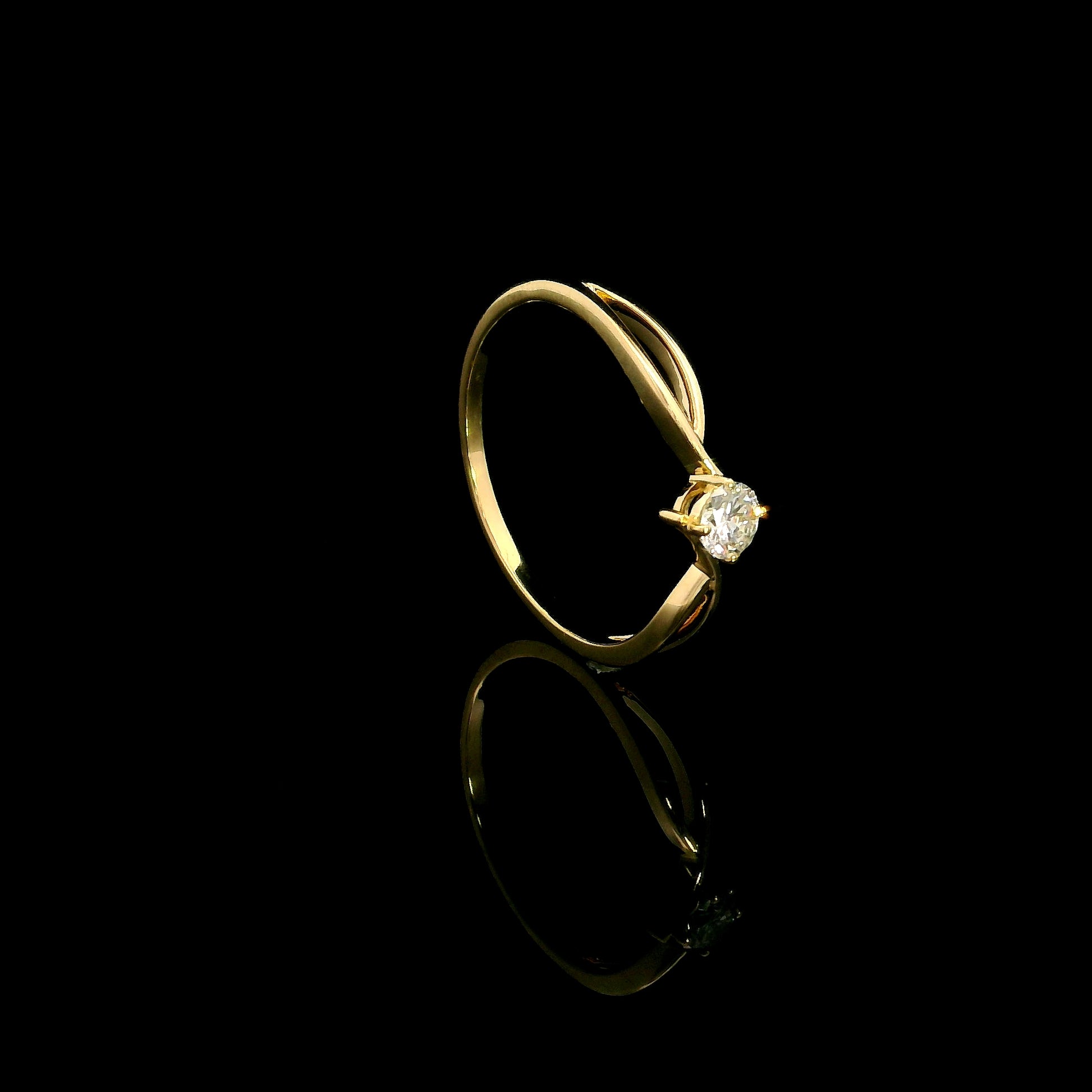 18K yellow gold twist solitaire ring featuring a 0.16 carat natural round brilliant diamond in a four-prong setting.