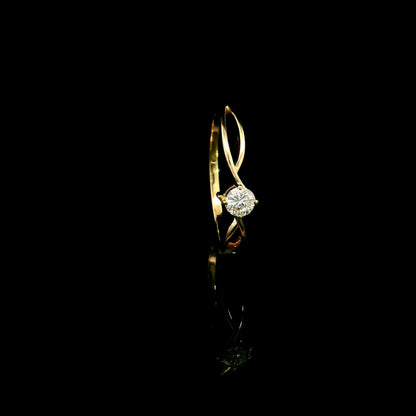 18K yellow gold twist solitaire ring featuring a 0.16 carat natural round brilliant diamond in a four-prong setting.