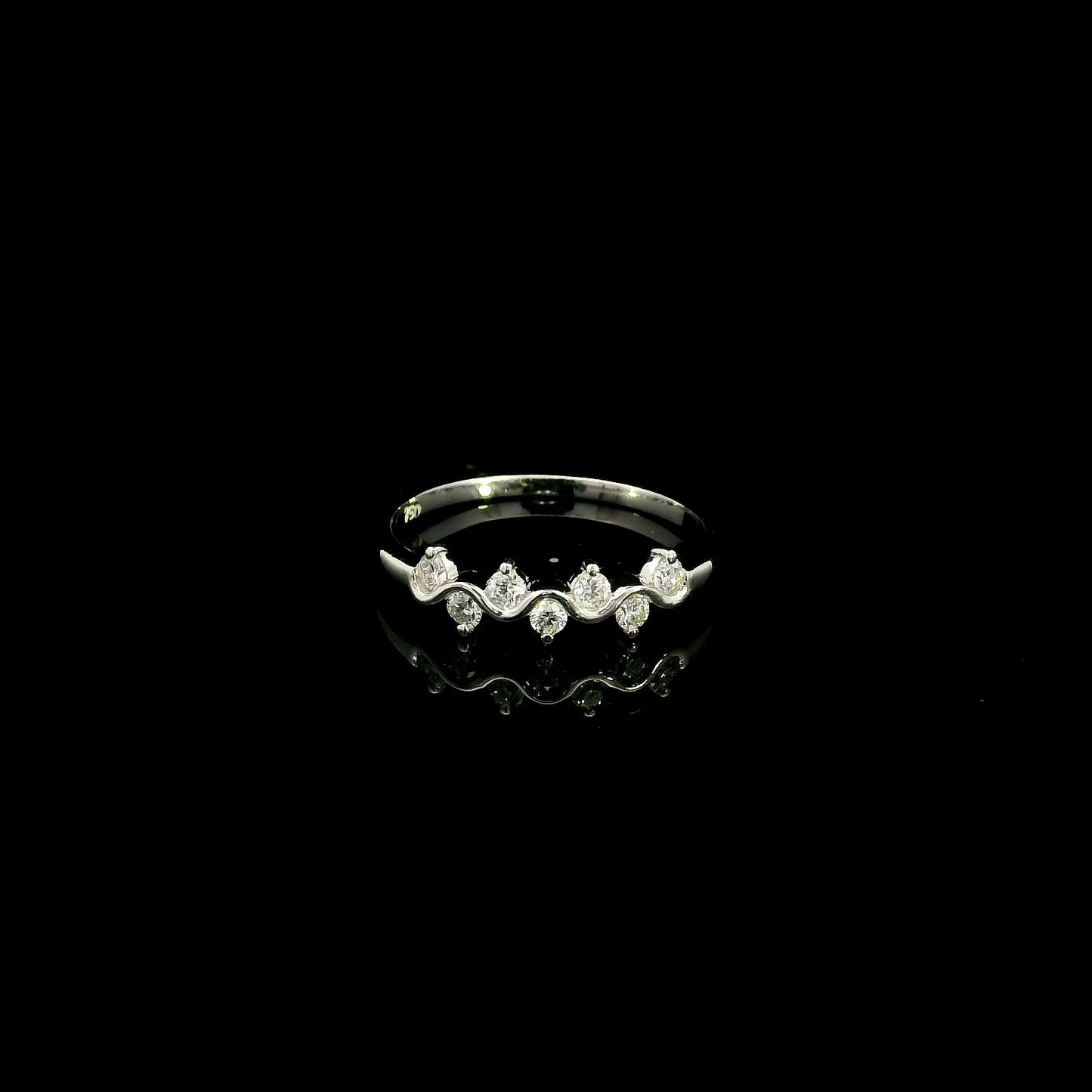 18K white gold diamond stack ring featuring natural round brilliant diamonds totaling 0.23 carat in a flowing shared prong design.