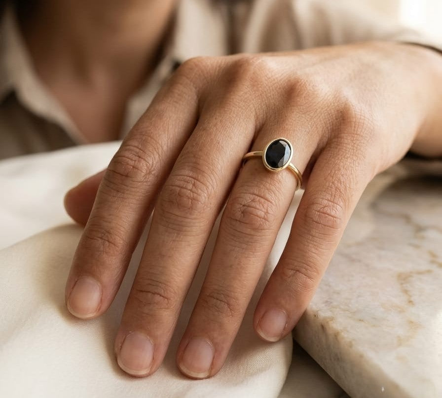 18K yellow gold oval blue sapphire bezel ring featuring a 2.19 Carat natural sapphire in a modern solitaire design.