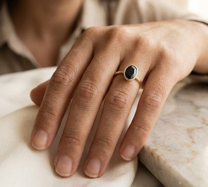 18K yellow gold oval blue sapphire bezel ring featuring a 2.19 Carat natural sapphire in a modern solitaire design.
