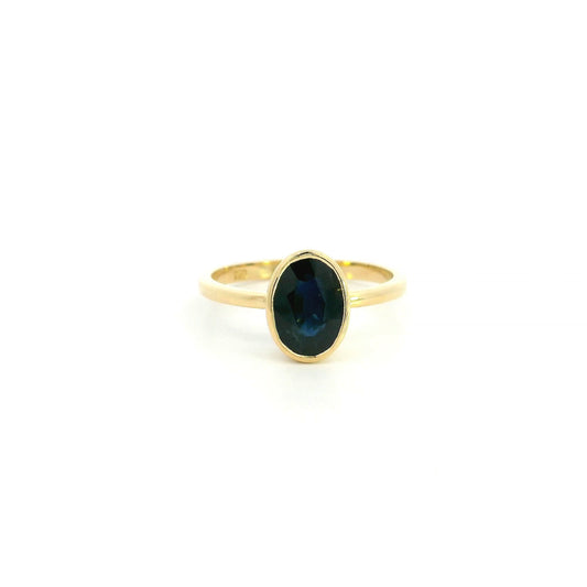 18K yellow gold oval blue sapphire bezel ring featuring a 2.19 Carat natural sapphire in a modern solitaire design.
