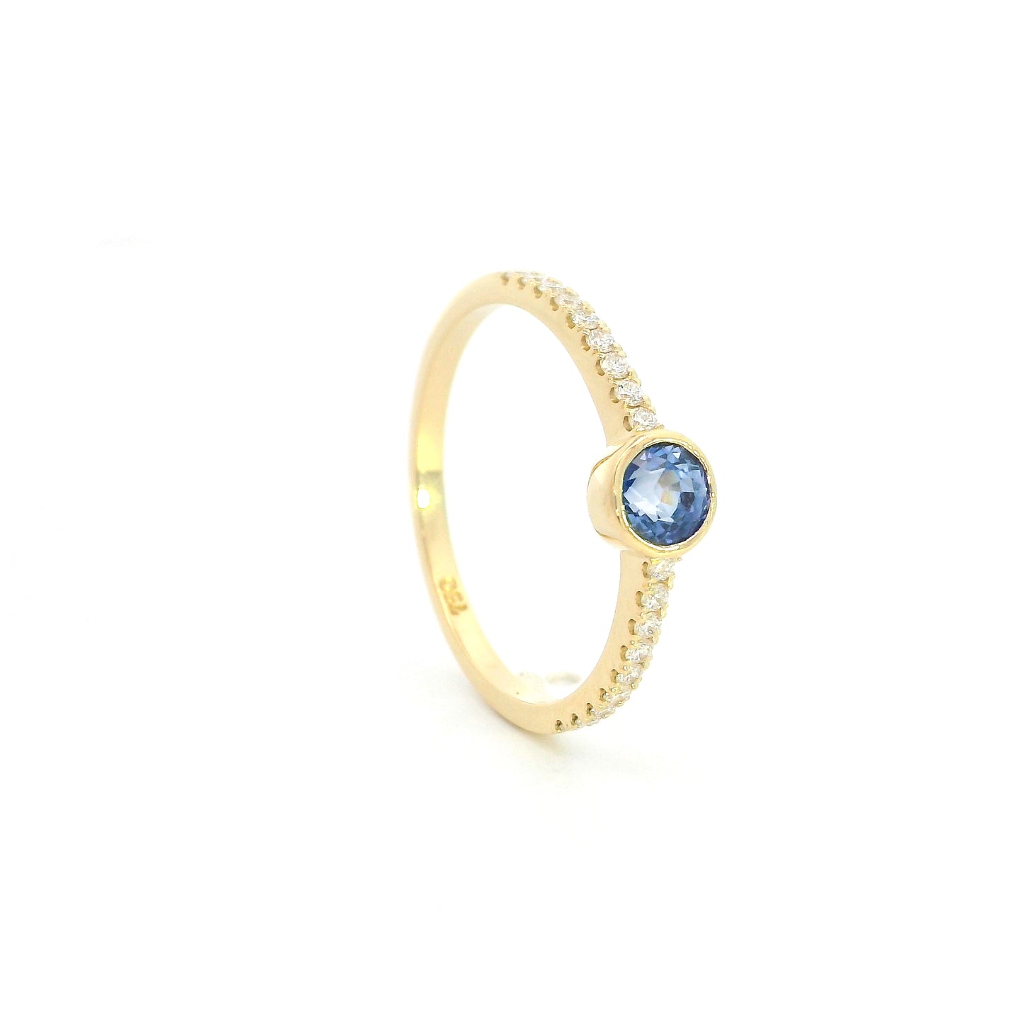18K yellow gold bezel blue sapphire diamond ring featuring a 0.62 Carat natural round sapphire with diamond-set shoulders.