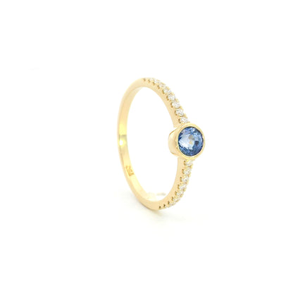 18K yellow gold bezel blue sapphire diamond ring featuring a 0.62 Carat natural round sapphire with diamond-set shoulders.