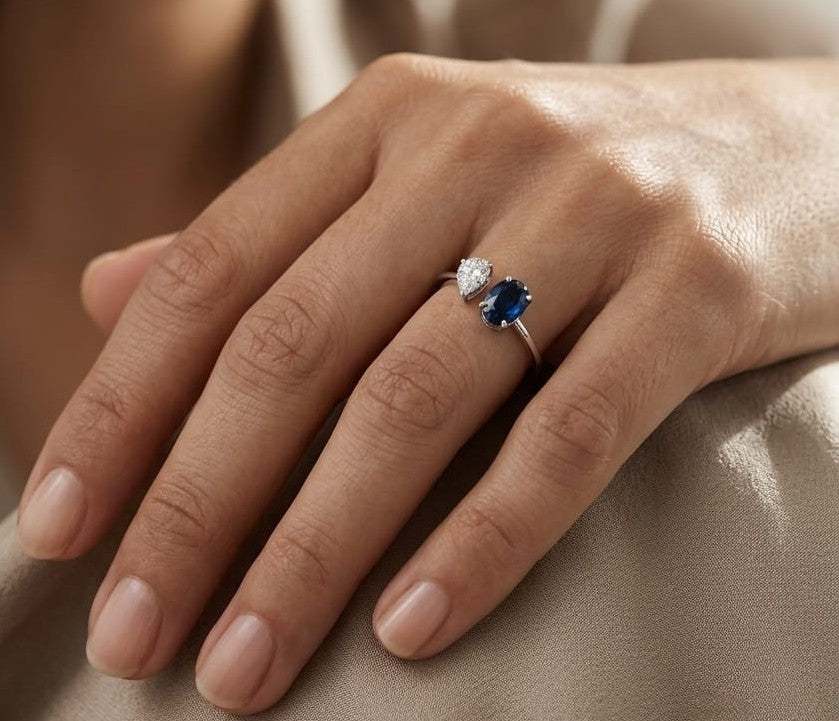 18K white gold blue sapphire diamond open ring featuring a 1.07 Carat natural oval sapphire with a pear-shaped natural diamond cluster.