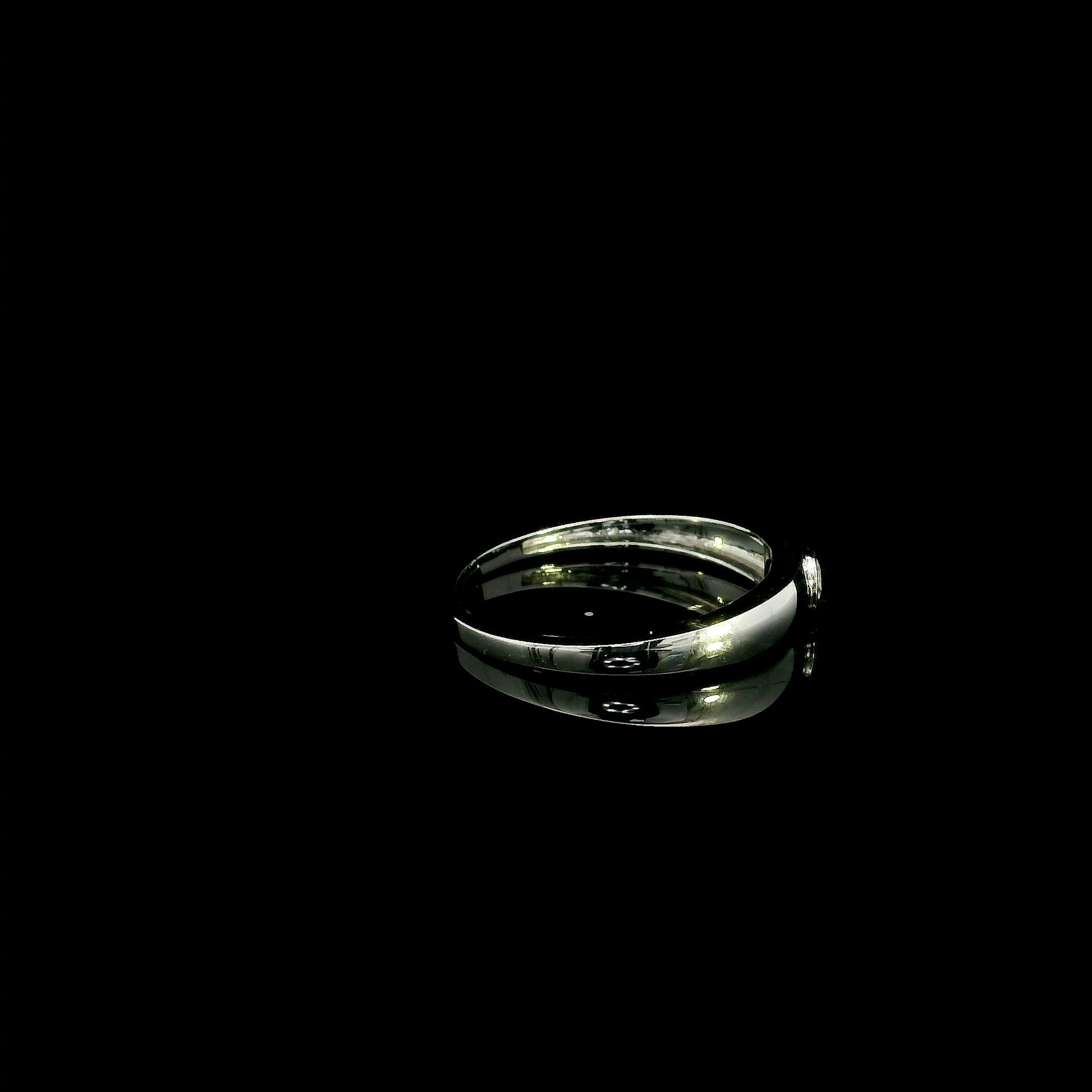 18K white gold bezel set solitaire diamond ring featuring a 0.11 carat natural round brilliant diamond with a smooth polished band.