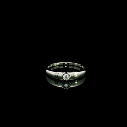 18K white gold bezel set solitaire diamond ring featuring a 0.11 carat natural round brilliant diamond with a smooth polished band.