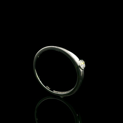 18K white gold bezel set solitaire diamond ring featuring a 0.11 carat natural round brilliant diamond with a smooth polished band.