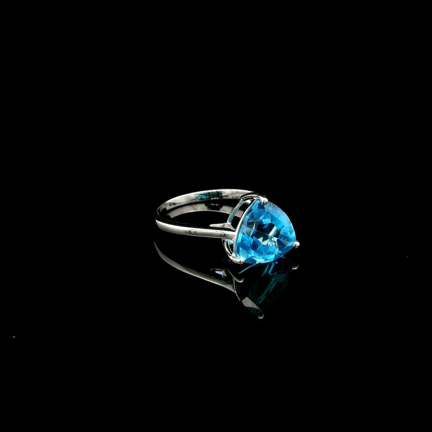 18K white gold solitaire ring featuring a 4.57 carat natural trillion-cut blue topaz in a contemporary three-prong setting.