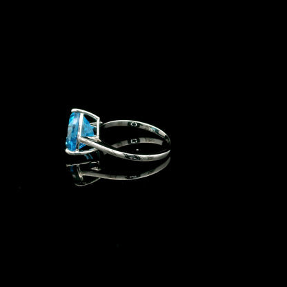 18K white gold solitaire ring featuring a 4.57 carat natural trillion-cut blue topaz in a contemporary three-prong setting.