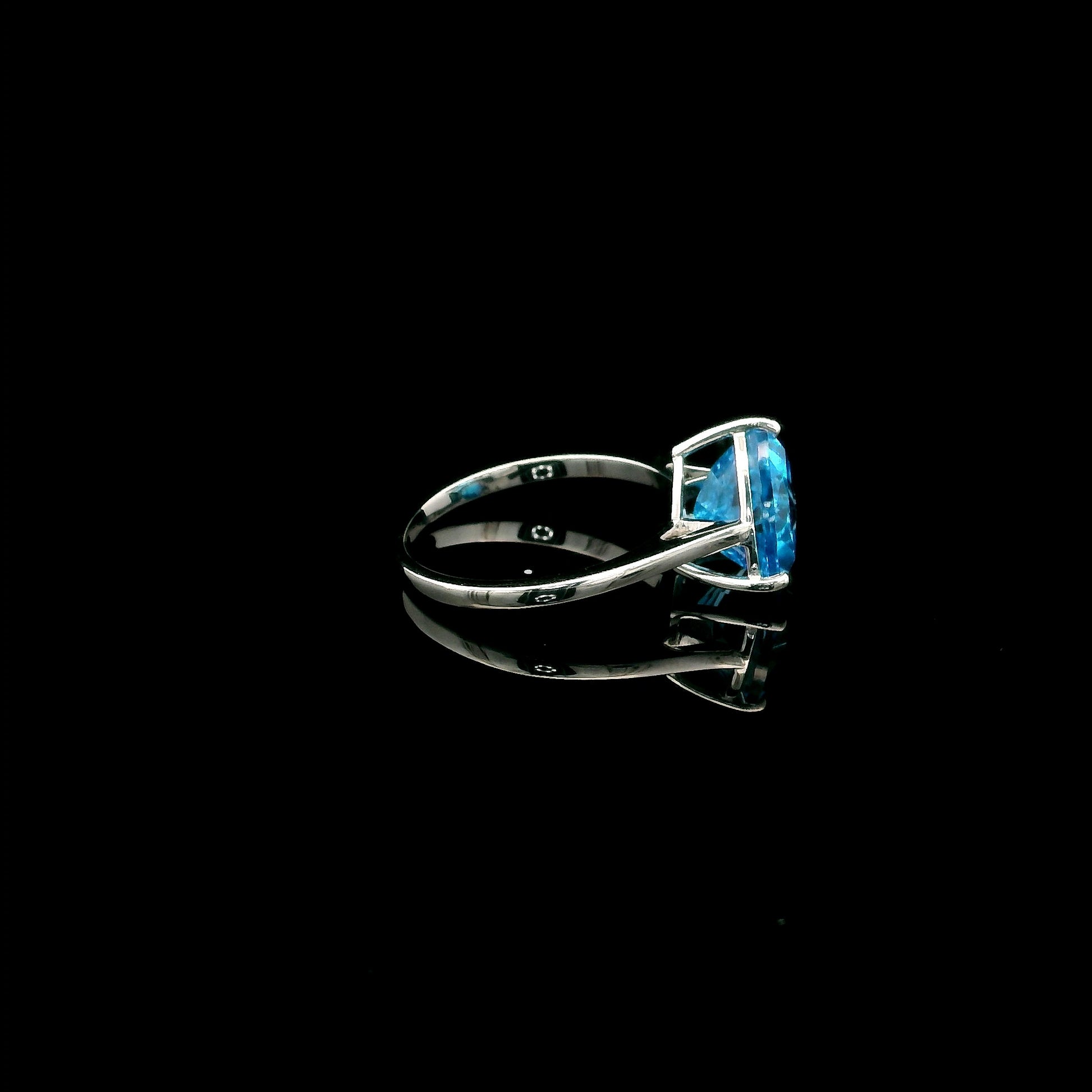 18K white gold solitaire ring featuring a 4.57 carat natural trillion-cut blue topaz in a contemporary three-prong setting.
