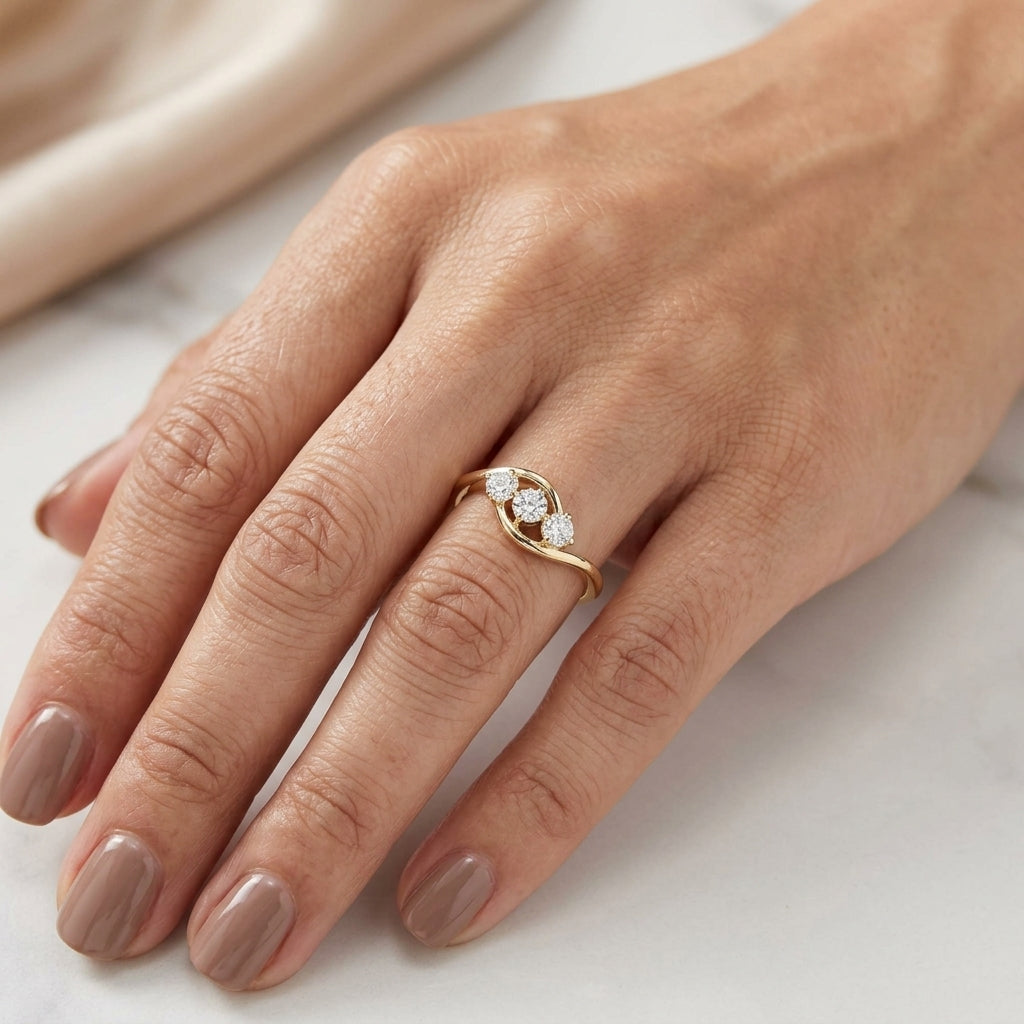 Three stone diamond ring in 18K yellow gold with round diamonds and flowing open band design