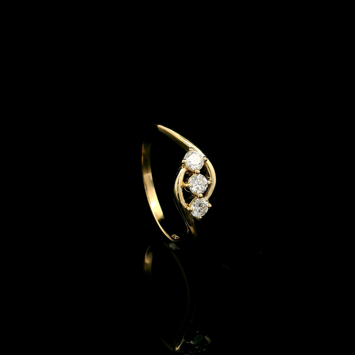 Three stone diamond ring in 18K yellow gold with round diamonds and flowing open band design