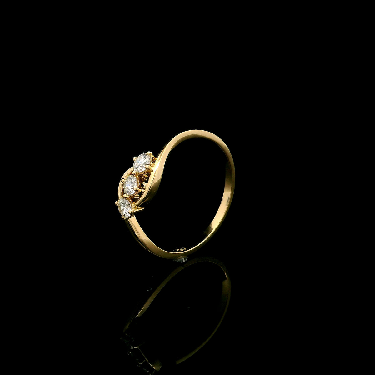 Three stone diamond ring in 18K yellow gold with round diamonds and flowing open band design
