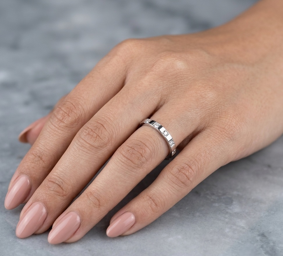 18K white gold diamond wedding band featuring five natural round brilliant diamonds in a modern flush-style polished band.