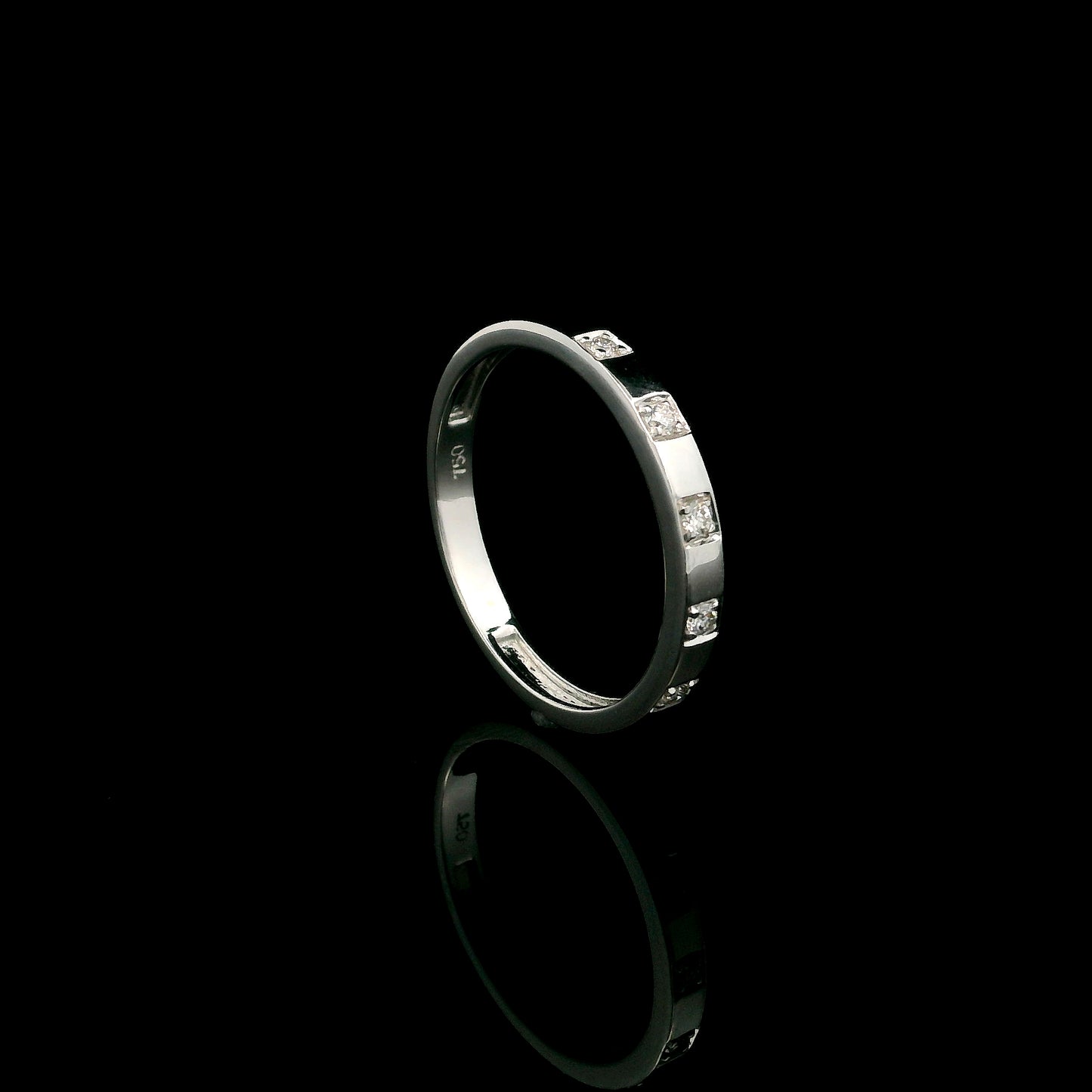 18K white gold diamond wedding band featuring five natural round brilliant diamonds in a modern flush-style polished band.