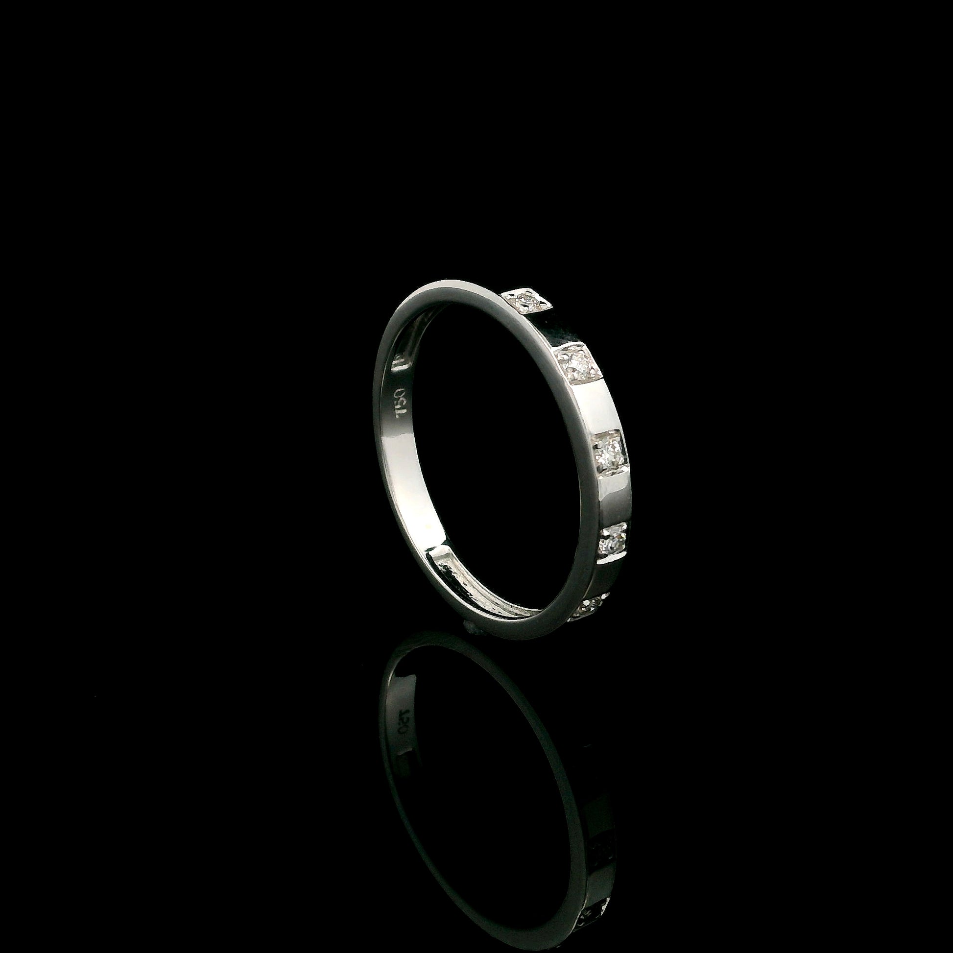 18K white gold diamond wedding band featuring five natural round brilliant diamonds in a modern flush-style polished band.