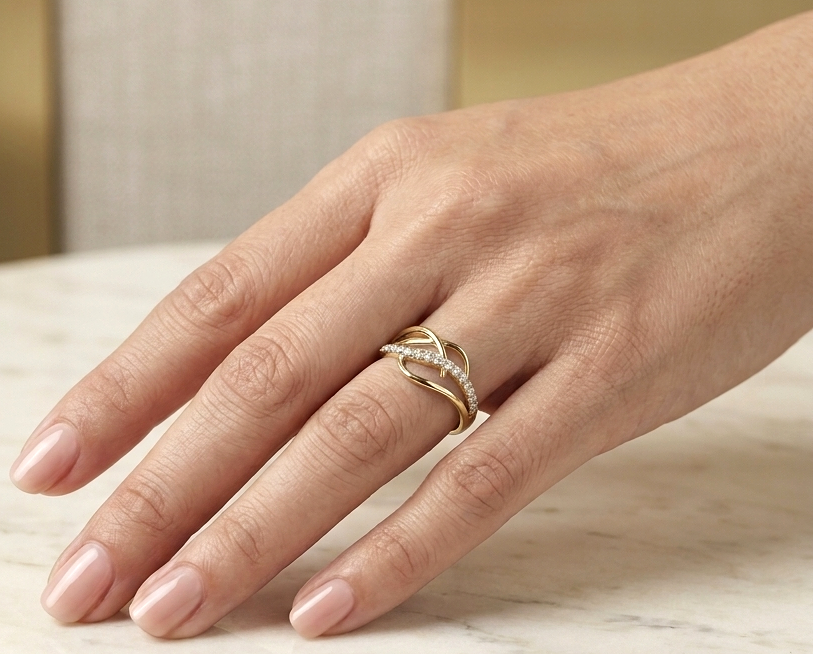 18K yellow gold interwoven diamond ring featuring flowing crossover bands and 0.22 carats of natural round brilliant diamonds.